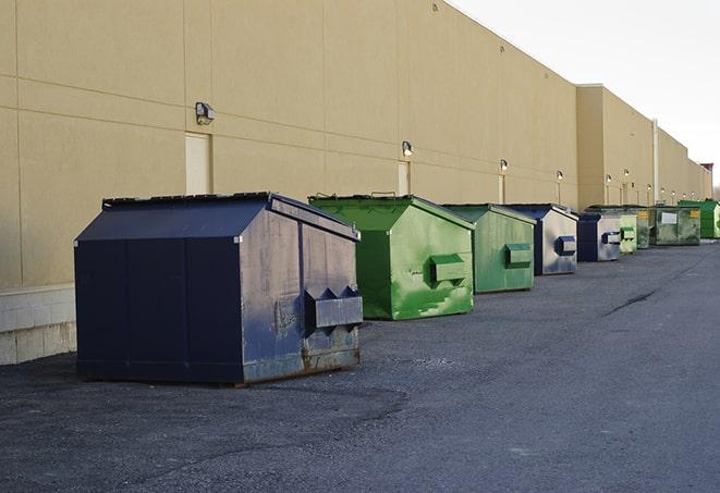 a construction worker moves construction materials near a dumpster in Blacklick